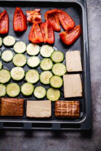 Tofu, Zucchini, Paprika auf ein Backblech geben