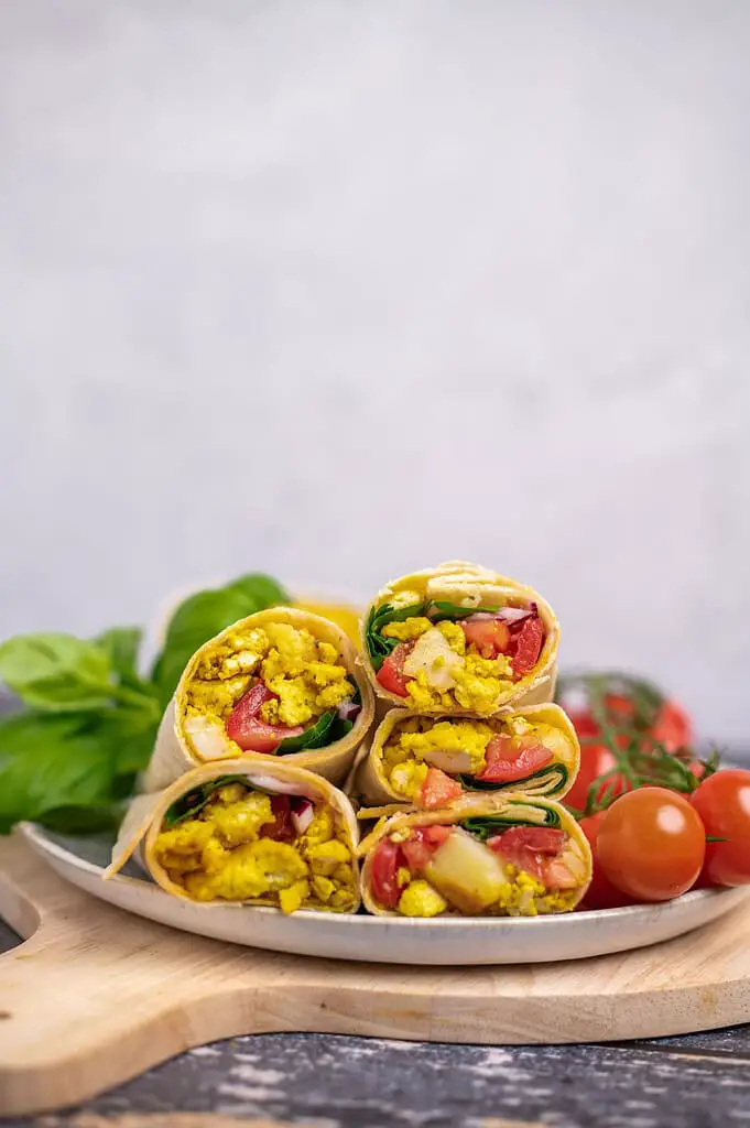 Vegan breakfast burritos filled with potatoes, scrambled tofu, spinach and tomatoes